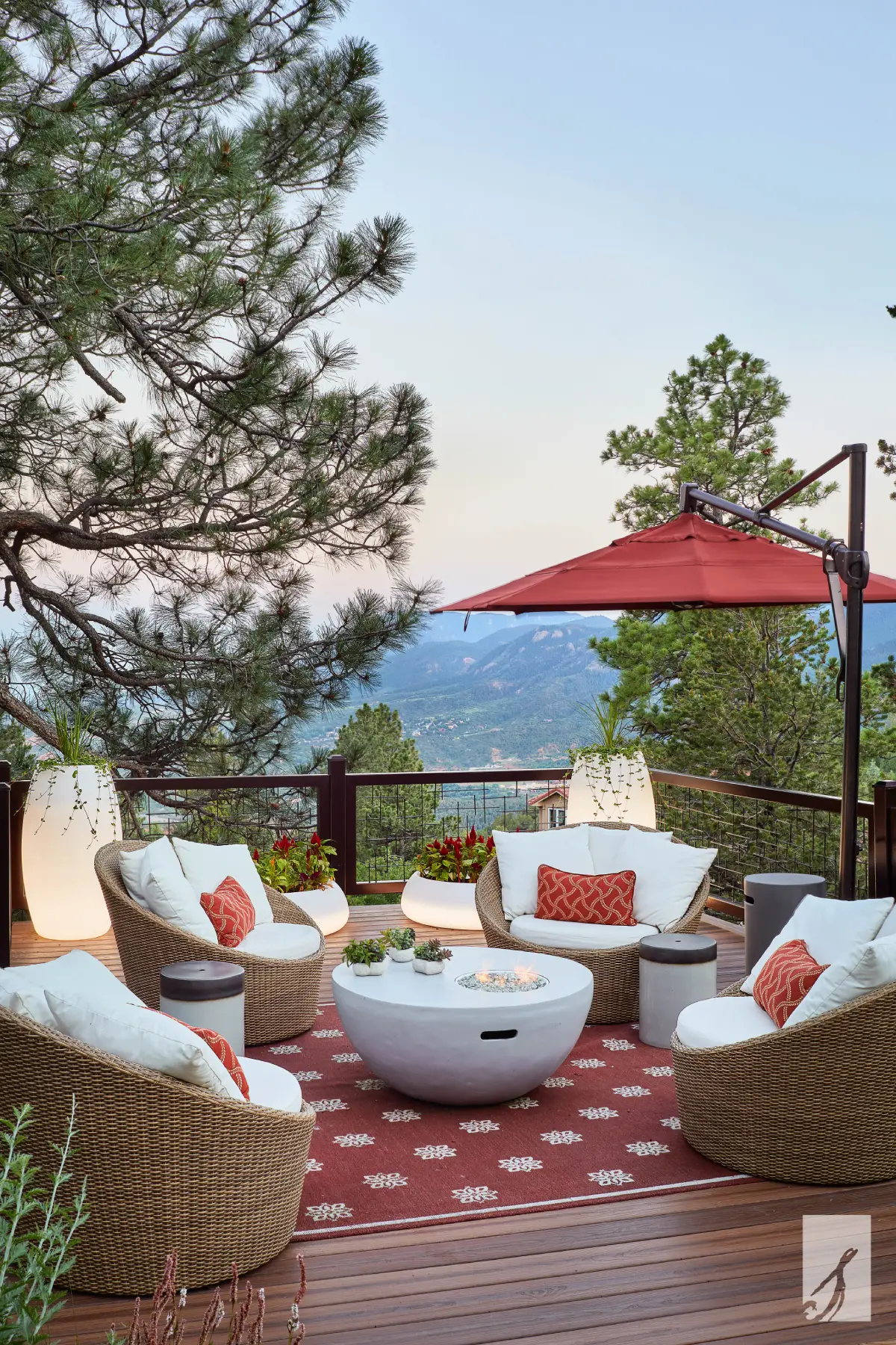 A luxurious outdoor seating area on a wooden deck with a mountain view.