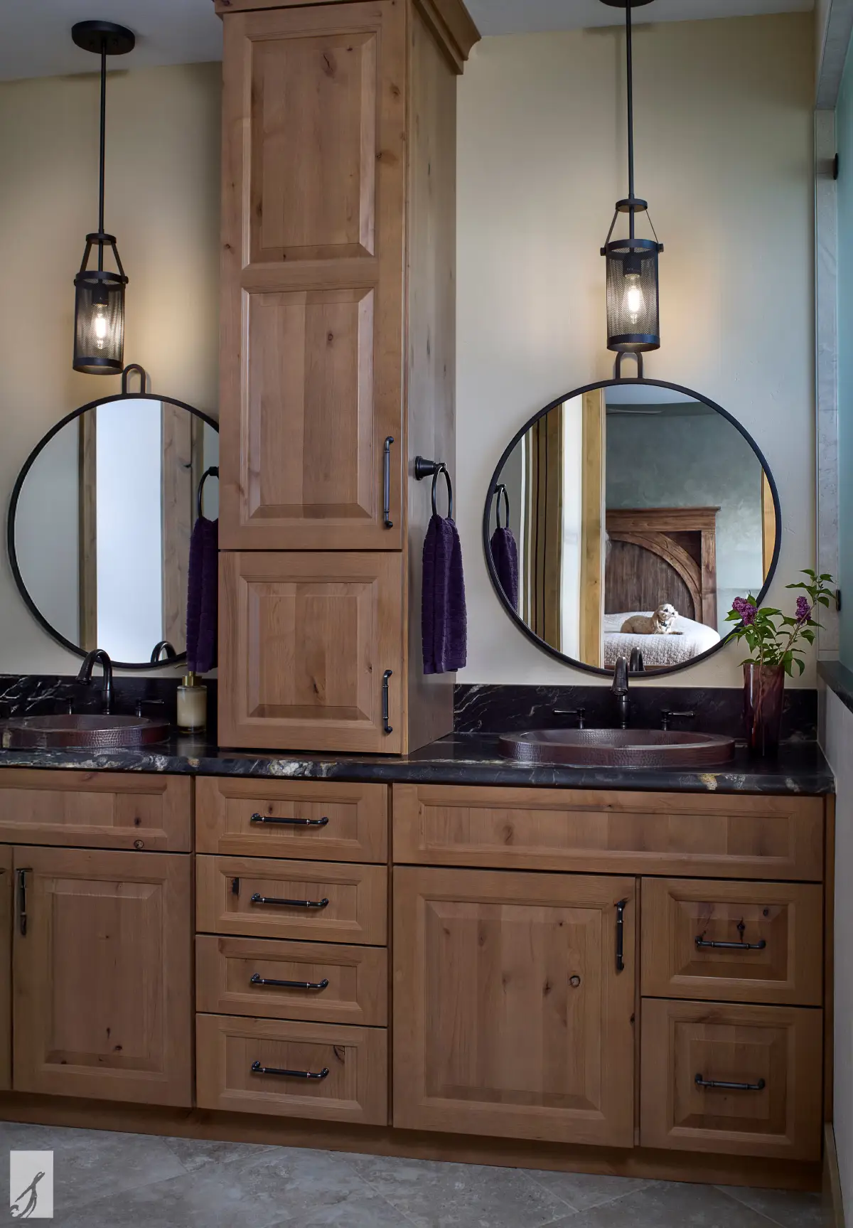 High Timber Hollow bathroom vanity with warm wood cabinetry, hammered metal sinks, round black-framed mirrors, and pendant lighting