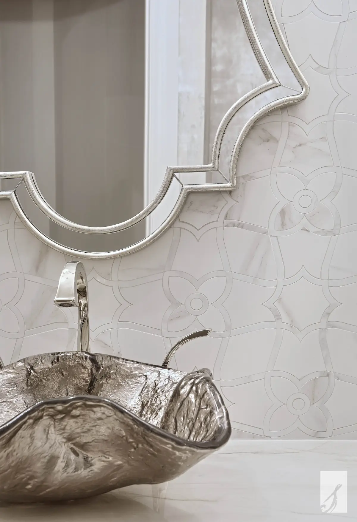 Windy Ridge Oasis powder room with a sculpted silver glass vessel sink, nickel faucet, decorative marble backsplash, and silver-framed mirror